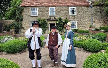 Pockerley at Beamish with three people dressed in period dress