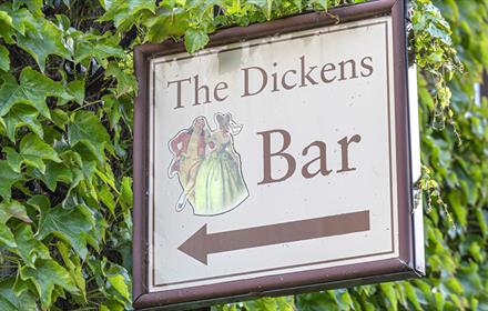 A sign saying The Dickens Bar