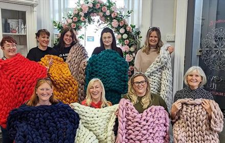 A group of women displaying their and knitted blankets