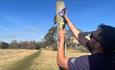 A person hammering a waymark for the Roof of England Walk onto a signpost.