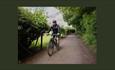 A man riding a bike along a single track road in the countryside