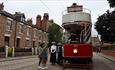 Image of the 1900s Town Street at Beamish Museum, people waiting to board the tram.