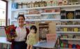 A member of staff holding a vintage doll at The Romer Parrish Toy Shop - Beamish Museum