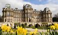 The exterior of The Bowes Museum and its grounds on a sunny day.