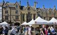 People shopping at market stalls in Durham Market Place.