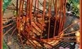 A willow basket part way through being woven