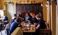 Group of people sat inside Vennels Cafe eating and drinking.