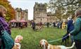 group of people standing with dogs listening to a speaker in the grounds of Raby Castle deer park.