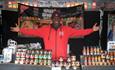 Man stood smiling holding up hands at camera on a food stall at Seaham Food Festival.
