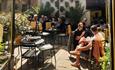 People sitting eating and drinking in the sunny courtyard of Vennels Cafe.
