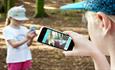 Two girls looking at the App on their phones,  Outdoors