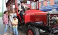 A family beside a vintage bus at Beamish Museum