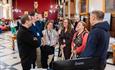 A group of attendees chatting and smiling in a circle during a conference networking session.