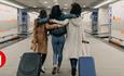 A group of friends pulling suitcases through an airport