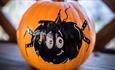 A pumpkin decorated with a painting of a spider