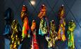 A selection of brightly coloured scarfs displayed on a dark background.