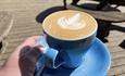 Coffee with latte art at Broom House Farm Coffee shop.