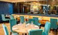 Dining area with blue seating and mirrored walls