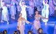 Dancers, in flowing pink dresses, performing with their arms outstretched on stage at Durham Fringe Festival