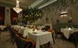 The Dining Room at Seaham Hall Hotel with tree decorations and candlelit tables.