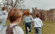 Two children running towards Raby Castle.