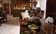 A woman in historical clothing preparing a table with traditional food - Georgian Drovers Tavern