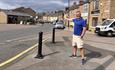 A gentleman smiling and pointing towards a street in Lanchester Village.