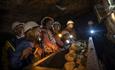 Children wearing hard hats in Killhope Lead Mine in dark truck full of rocks