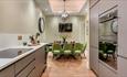 Light coloured kitchen with neutral walls and light grey units on either side. One side has drawers and an induction hob. Dining area.