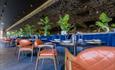Different view of tables and chairs with plants in background