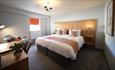 Large double room at The Park Head Hotel with an ample desk and bedside chair.
