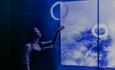 Passage of Ra by Studio Swine. Silhouette of a woman looking upwards at abstract art.