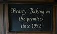 A sign in Vennels Cafe with the wording Hearty Baking on the premises since 1992