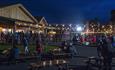 People sitting under fairy lights, enjoying the Food Court at Pyromusical 2024.