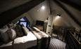 Interior of image of luxury treehouses at Ramside Hall Hotel. Large comfortable beds with lots of cushions on them.