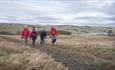 4 walkers traversing the countryside - Roof of England Walk.