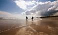 Surfers walking into sea