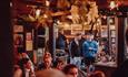 People enjoying drinks at The Hotspot Bar under soft lighting.