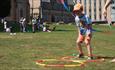 A child playing with Hula Hoops on grass on a sunny day