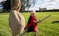 A child in medieval clothing practicing sword play