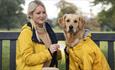 A woman sitting on a bench with a golden retriever in matching yellow coats