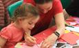 An adult and little girl enjoying crafts activities.