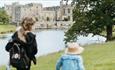 A woman and two children walking in front of the lake at Raby Castle