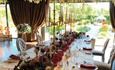 Wedding table adorned with candles and floral centre pieces, overlooking a verdant outdoor space at Bowburn Hall Hotel