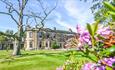 Beamish Hall Country House Hotel exterior, with purple spring flowers emerging in the foreground.