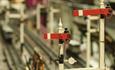 A miniature scale of two red train signals.
