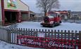 Winter Wonderland at Adventure Valley - a snowy landscape featuring a train and rides in the background