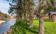 View of lodges looking over the river with grass and trees lining the edge