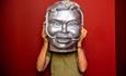 A person holding a sculpture of a human face - 'Humanimals' exhibition at Ushaw