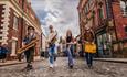 Yorky Pud Street Band walking through a city as they perform.